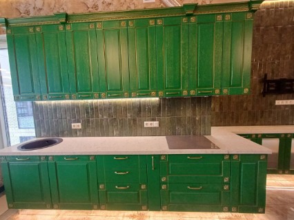 Белая кварцевая столешница в контрасте с зелеными фасадами
