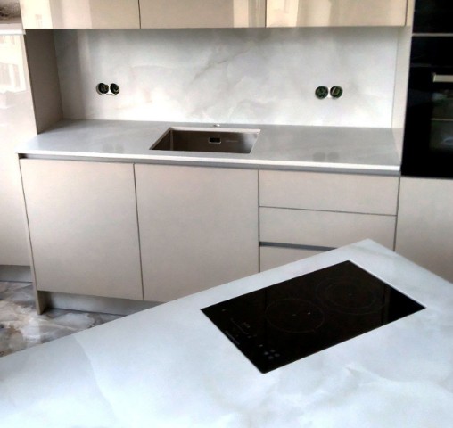 Белоснежная кухня с глянцевыми столешницами из кварца