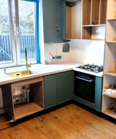 Белая глянцевая столешница с газовой плитой и золотой мойкой