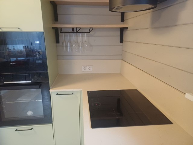 Кухня с глянцевой столешницей в теплых молочных тонах