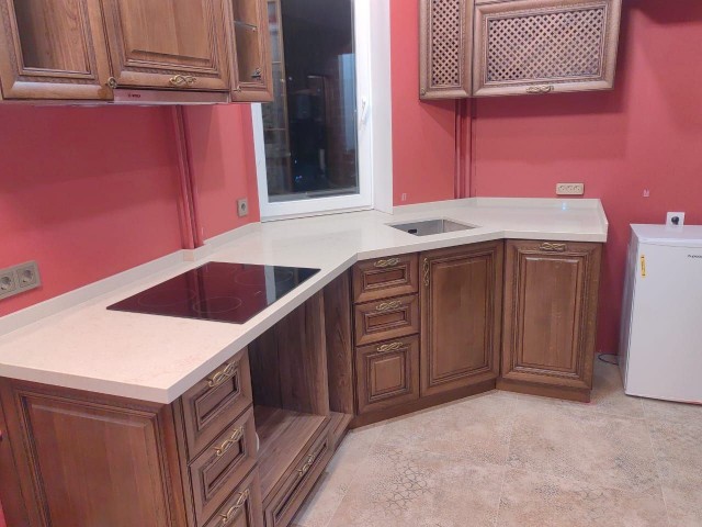 Фигурная белая столешница как акцент в интерьере кухни