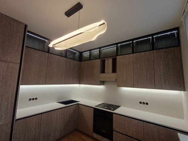 Белоснежная кварцевая столешница в контрасте с деревянными фасадами